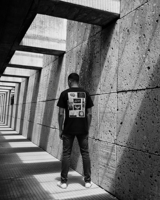 Person standing in a sunlit concrete corridor with geometric patterns.