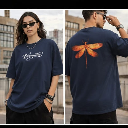 Model wearing a black oversized T-shirt with printed logo on the front and a dragonfly graphic on the back.”